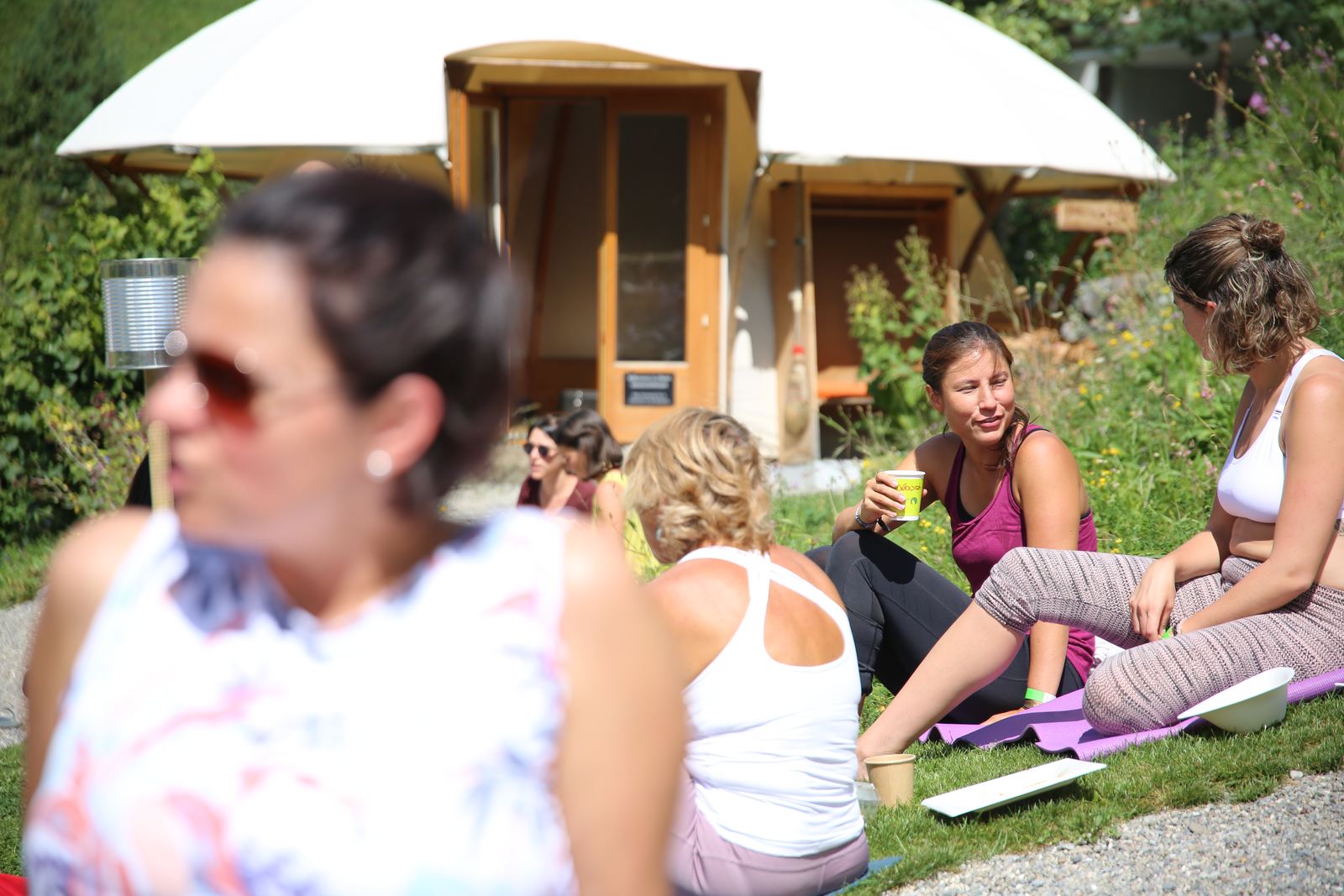 Teilnehmerinnen machen Pause auf der Wiese vor der Jurte am Kientalerhof