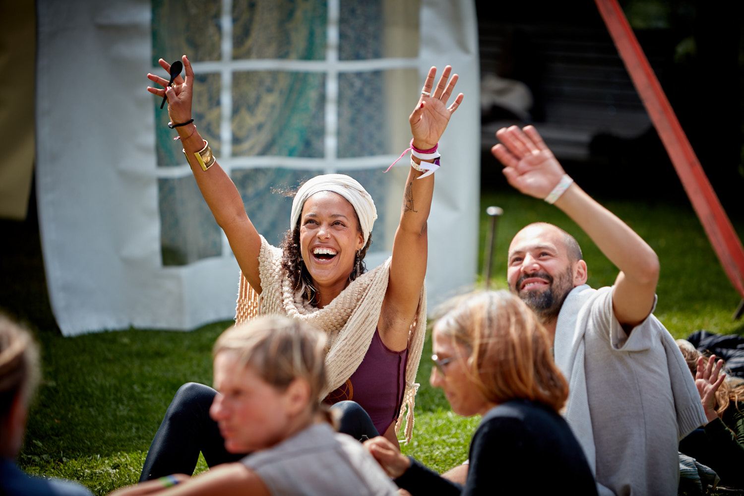 Lachende Teilnehmende auf der Wiese beim Yogafestival Summer of Love im Kiental